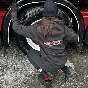 Schwarzer Heinrichs Thermoliner Hoodie im Einsatz am Truck – authentisches Anwendungsfoto für LKW-Zubehör und Arbeitskleidung