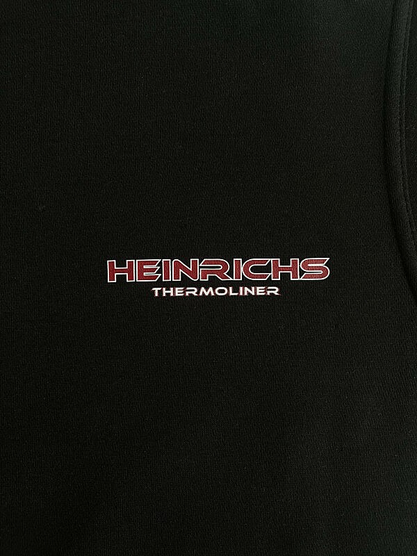 Heinrichs Thermoliner Rückenlogo – Detailaufnahme des roten Schriftzugs auf schwarzem Hoodie