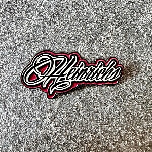 Metall-Pin mit „Heinrichs“-Logo-Schriftzug in Schwarz-Rot, ideal für Trucker, Fans und Sammler – Hängerzug-Style to go.