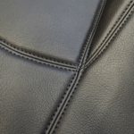 Feinstrukturiertes schwarzes Kunstleder mit sauberer Doppelnaht Nahaufnahme