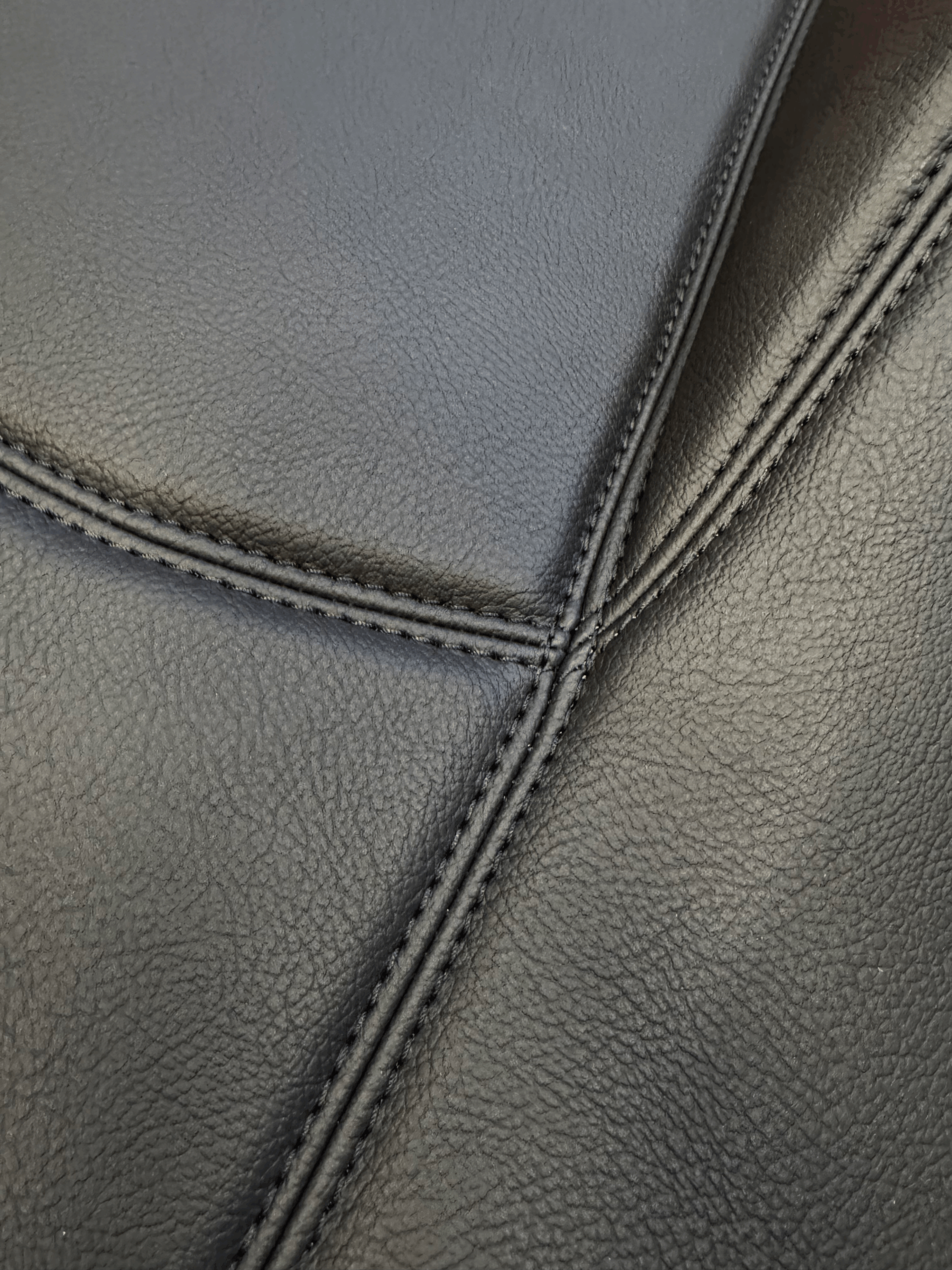 Lederboden-individuell-special-interior.png Feinstrukturiertes schwarzes Kunstleder mit sauberer Doppelnaht Nahaufnahme