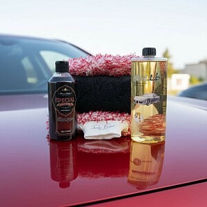 Erweitertes Premium Fahrzeug Pflege-Set mit Bürstenüberzug, Trockentuch, Shampoo und Aktivschaum auf roter Motorhaube